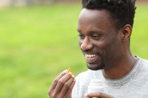 african american man taking vitamin in the park